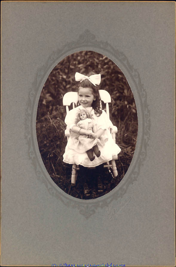 Old Photograph of a Young Girl in a Dress & Bow with Porcelain Toy Doll
