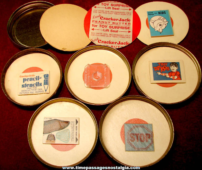 (6) Early 1970s Cracker Jack Peanut Butter Jar Advertising Lids with Different Unopened Toy Prizes